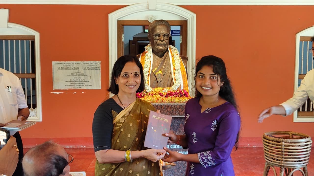 A participant receiving a book beside the poet's statue