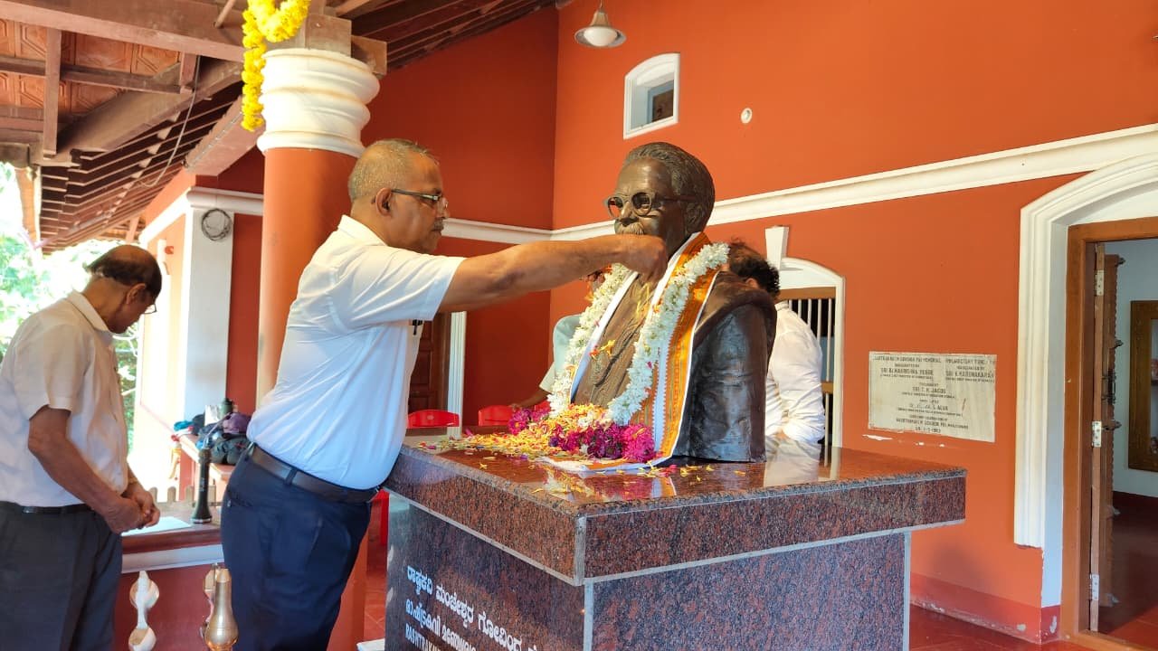 A floral garland being placed on the poet's statue